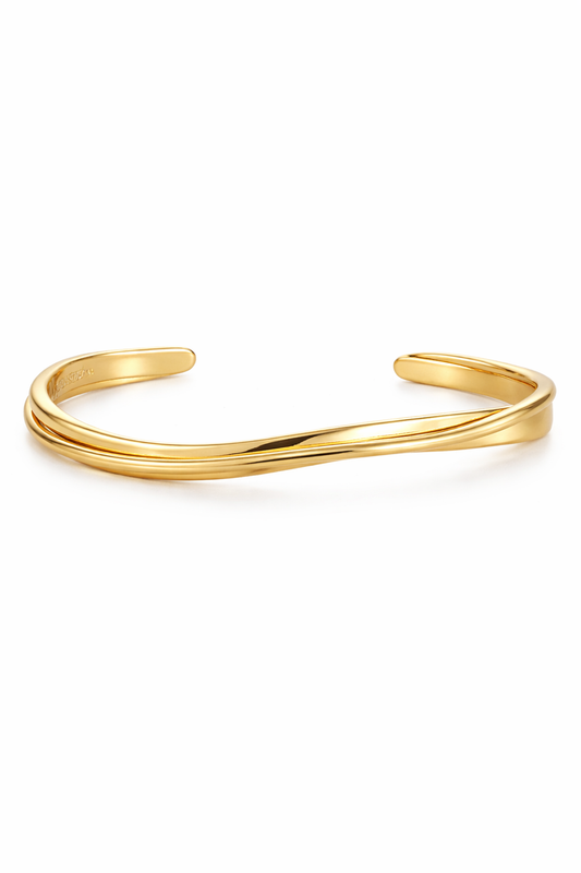 Amaya Élan Wave Cuff Armband aus goldfarbenem Metall mit wellenförmigem Design auf weißem Hintergrund